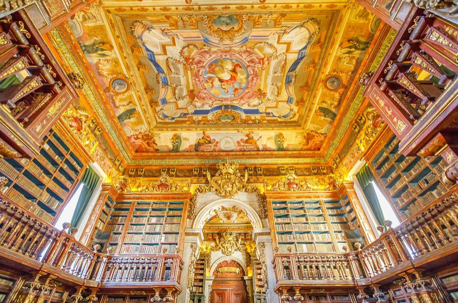The ornate interior of the Joanina Library at the University of Coimbra